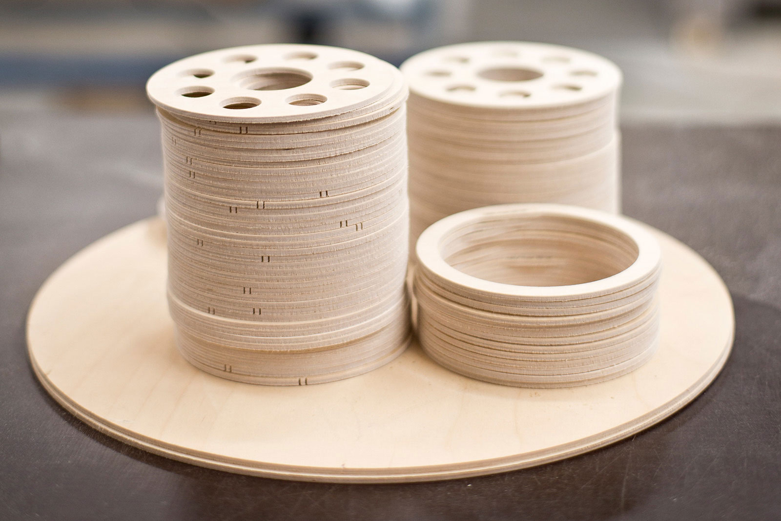 A close-up of three piles of the wooden rings used in some Secto Design lampshades.