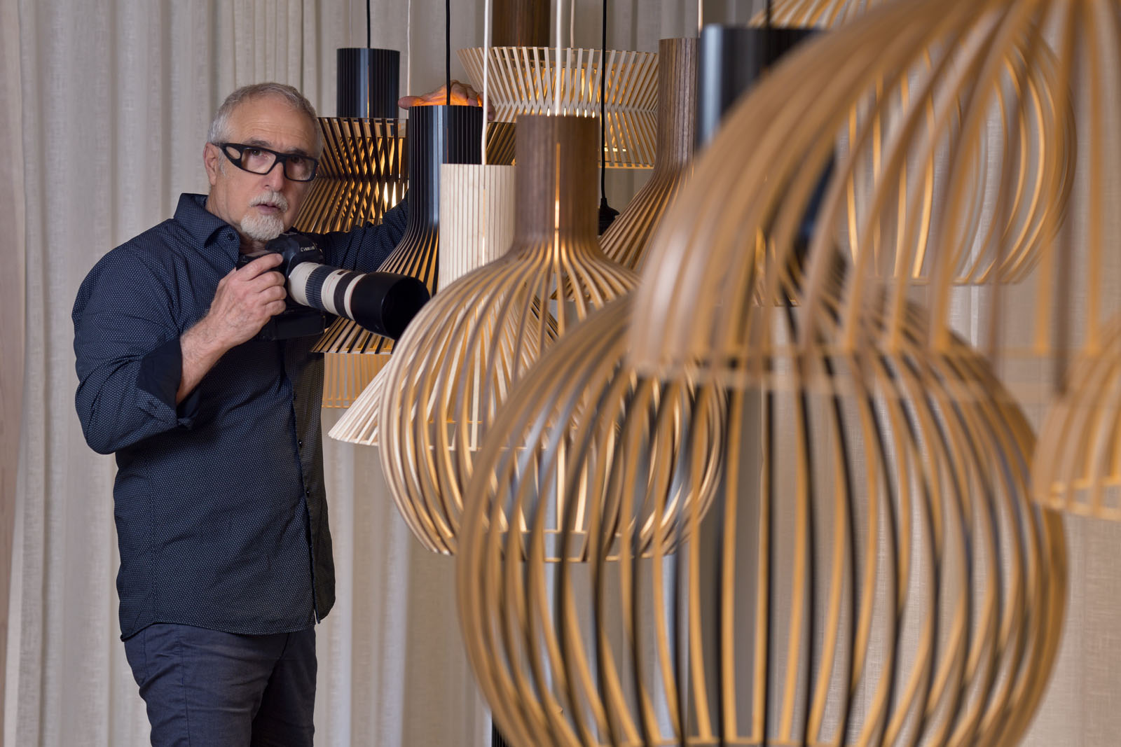 A photographer next to a group of Secto Design lamps.
