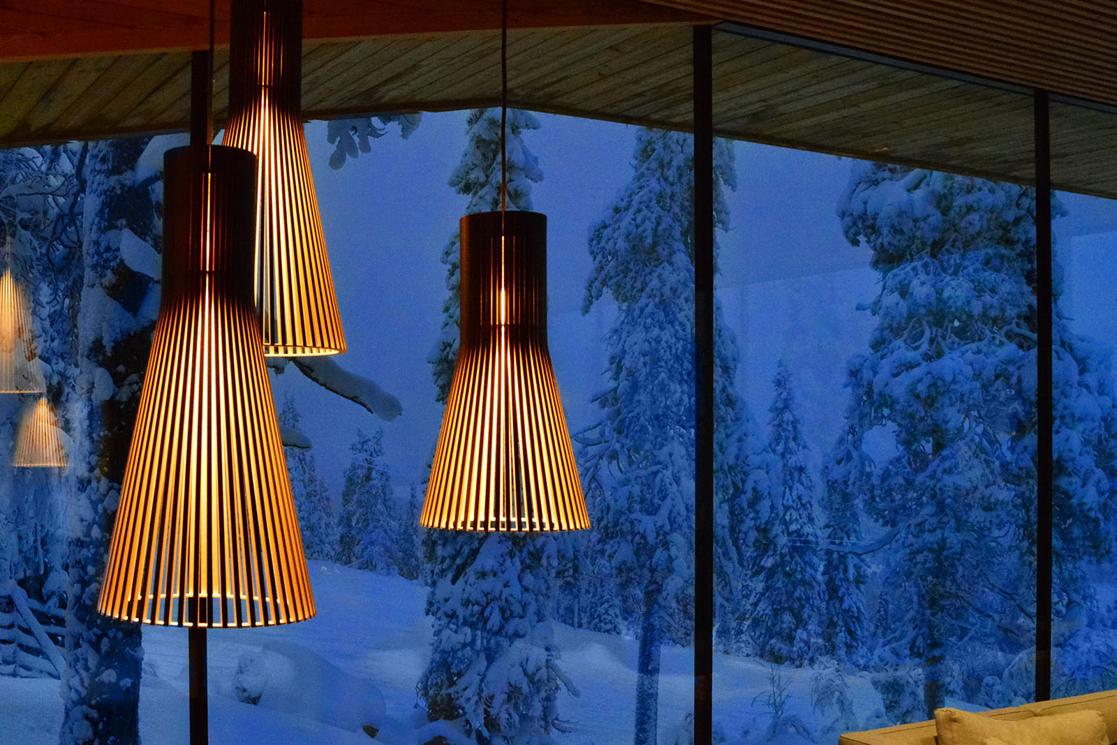 Three pendant lamps in front of a blue, snowy scenery outside the window.