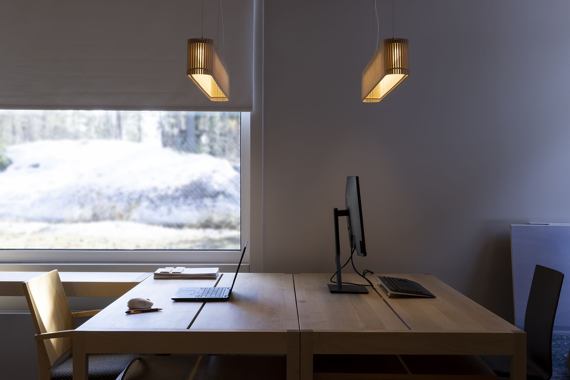 Two pendant lamps above two workstations.